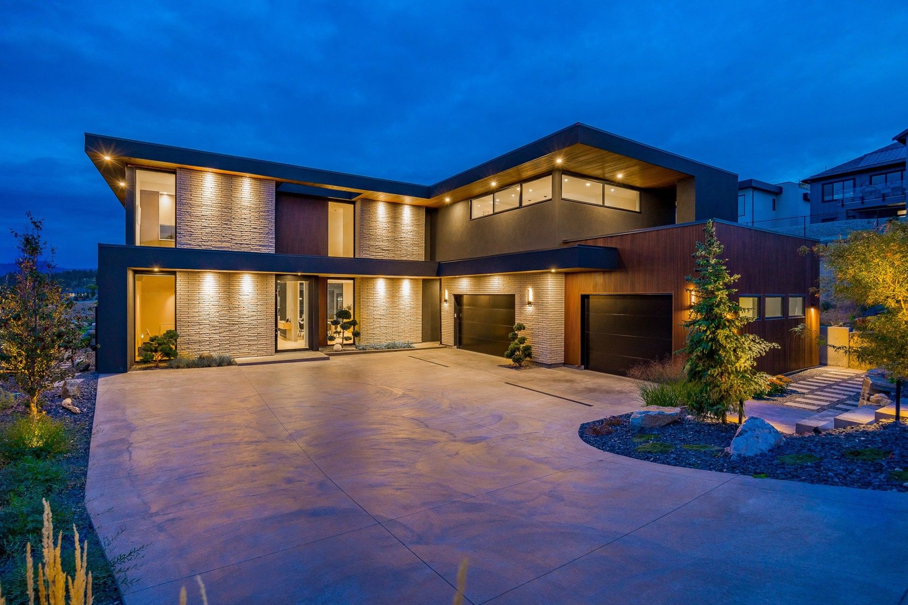A modern Kelowna home lit up at dusk